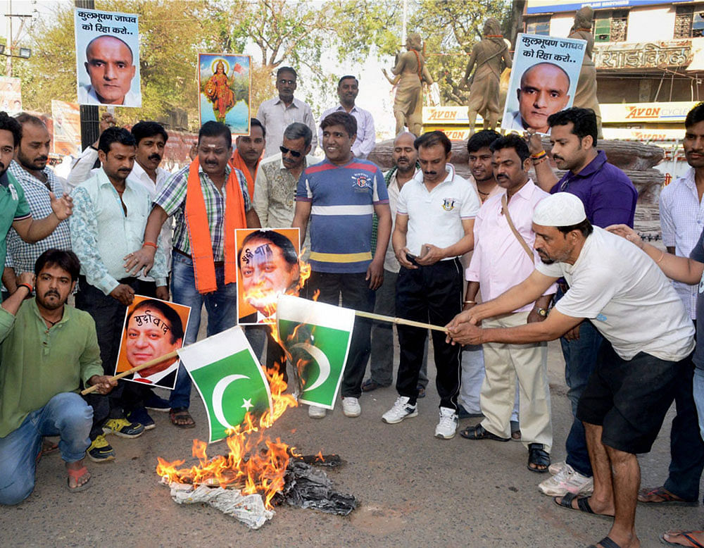 People burn Pakistani flag during a protest against the awarding of death sentence to former Indian navy officer Kulbhushan Jadhav by a Pakistani Court, in Varanasi. PTI File Photo