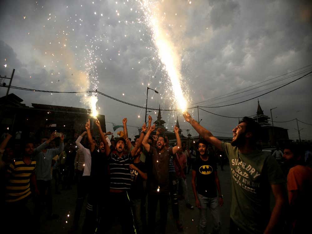 Kashmiris light fire crackers as they celebrate India losing two early wickets during the Champions Trophy cricket final match between India and Pakistan, in Srinagar on Sunday. PTI Photo