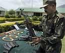 An army man displaying arms and ammunition seized from suspected Lashkar-e-Taiba militants at the Reasi army headquarters in Jammu and Kashmir on Friday. PTI