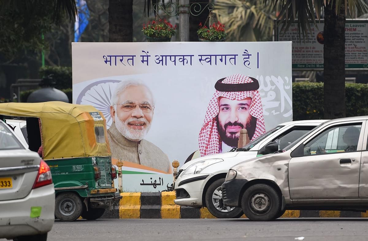 Vehicles drive past a billboard displaying the portrait of Indian Prime Minister Narendra Modi and Saudi Arabian Crown Prince Mohammed bin Salman ahead of his official visit to India, in New Delhi on February 19, 2019. (AFP)