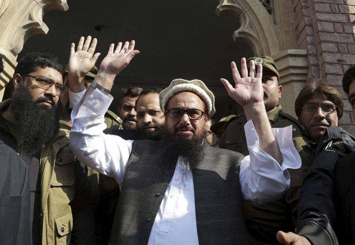 Hafiz Saeed, head of Jamaat-ud-Dawa, waves on his arrival to a court in Lahore on November 21, 2017. AFP