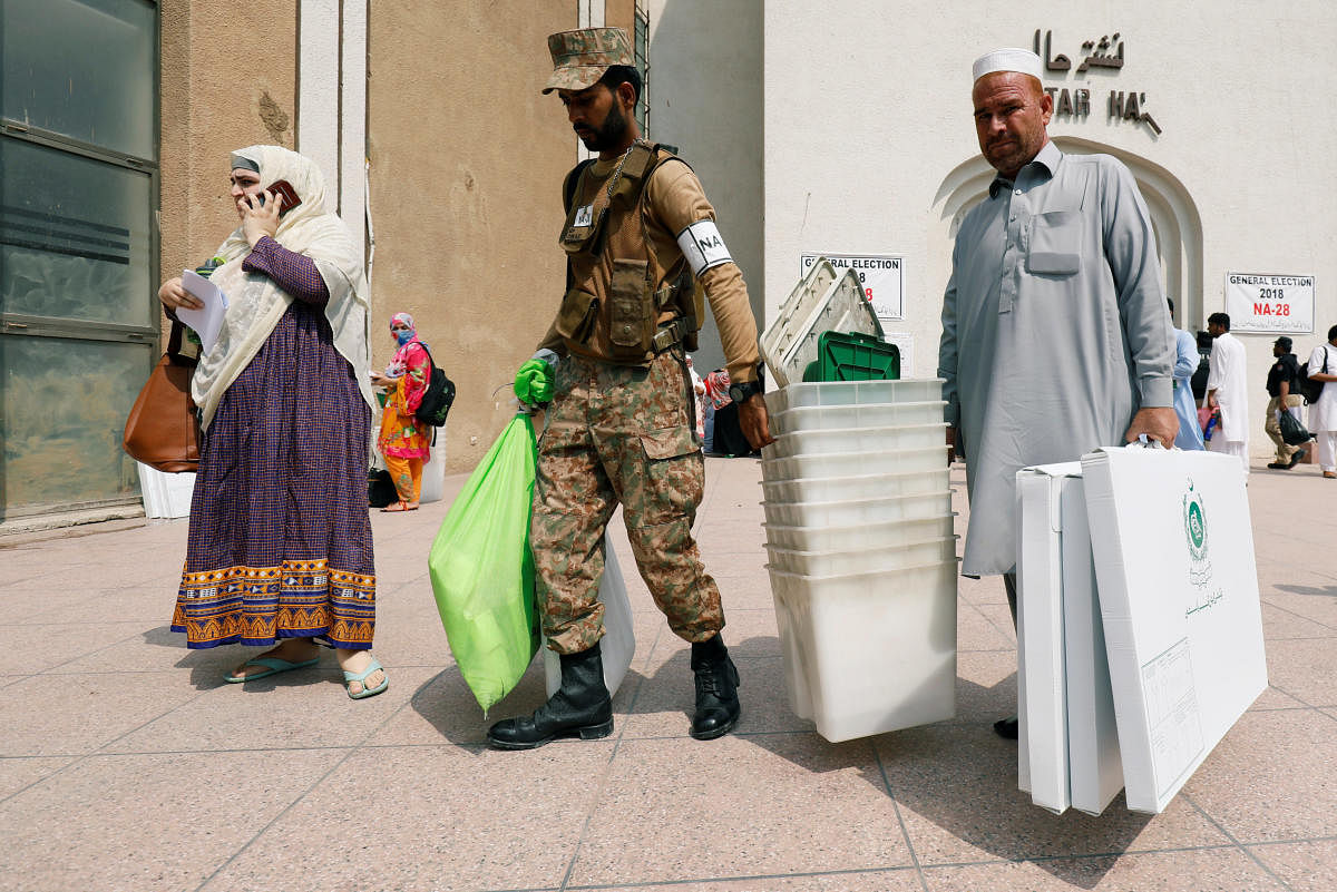 Army soldier helps electoral workers after collecting election materials from a distribution point, ahead of general election in Peshawar, Pakistan on Tuesday. (REUTERS/Fayaz Aziz)