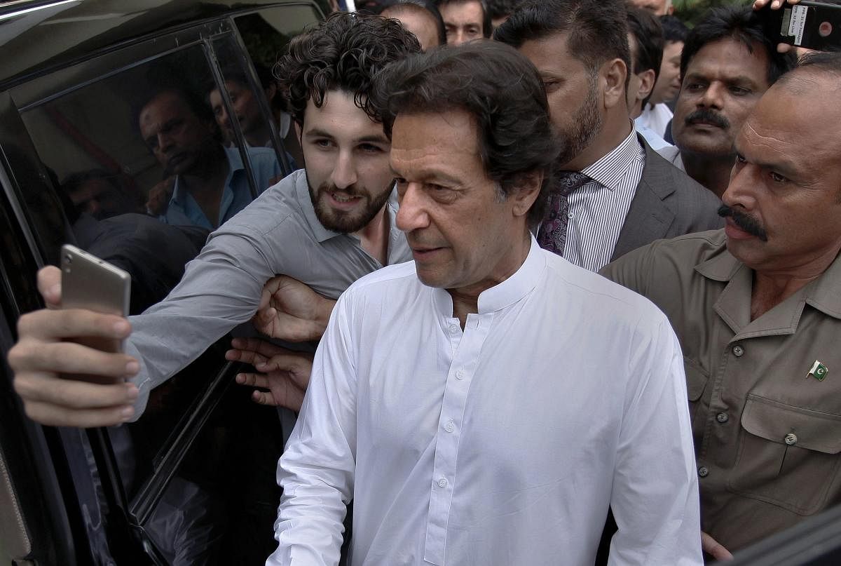 A Pakistani takes selfie with Imran Khan, center, head of the Pakistan Tehreek-e-Insaf party, as he leaves a party meeting in Islamabad, Pakistan, Monday, Aug. 6, 2018. The party won the most parliament seats in last month's general elections and is expected to form a governing coalition later this month. (AP/PTI)