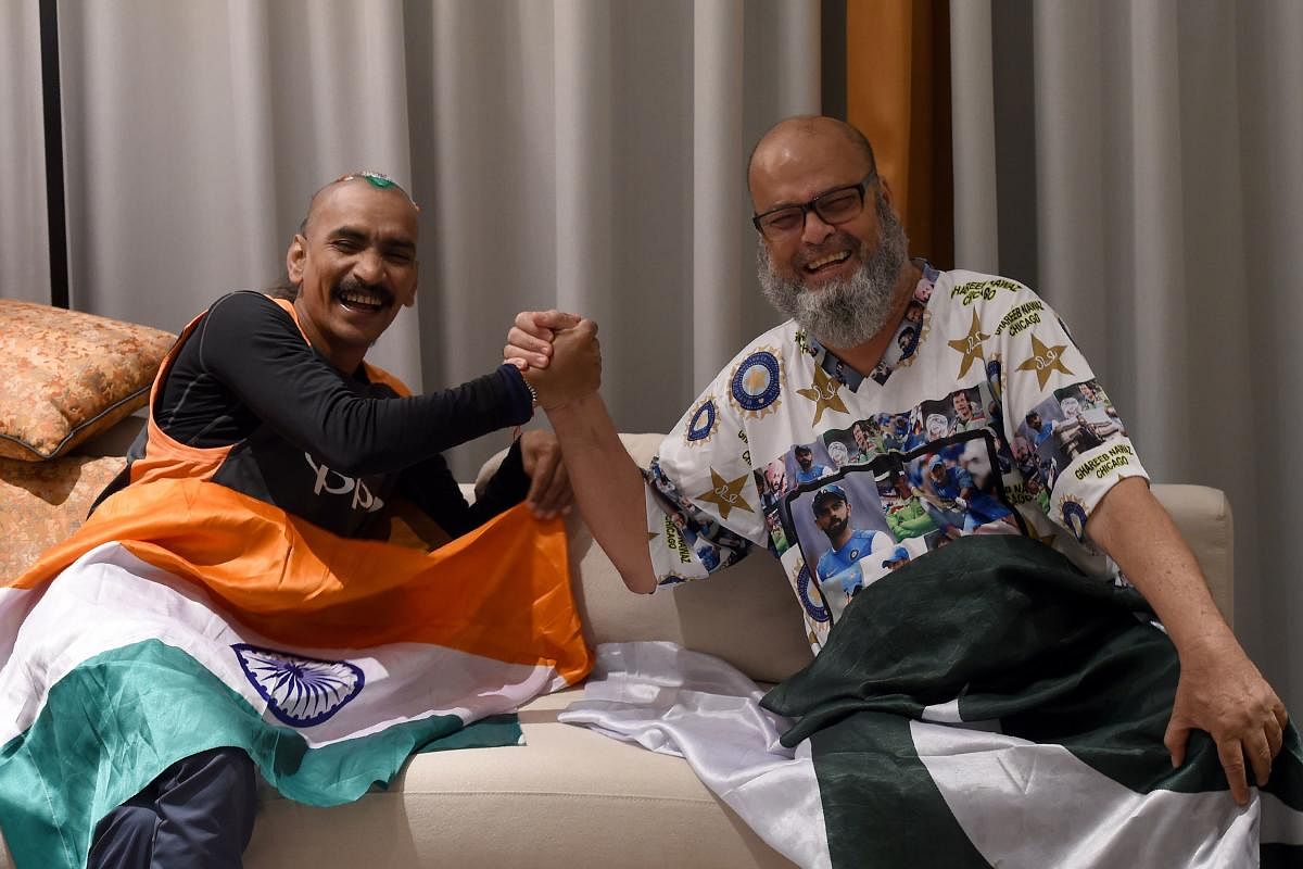 India cricket fan Sudhir Kumar (left) and Pakistan fan Mohammad Basheer share a laugh. Basheer has sponsored Sudhir's trip to the Asia Cup. AFP