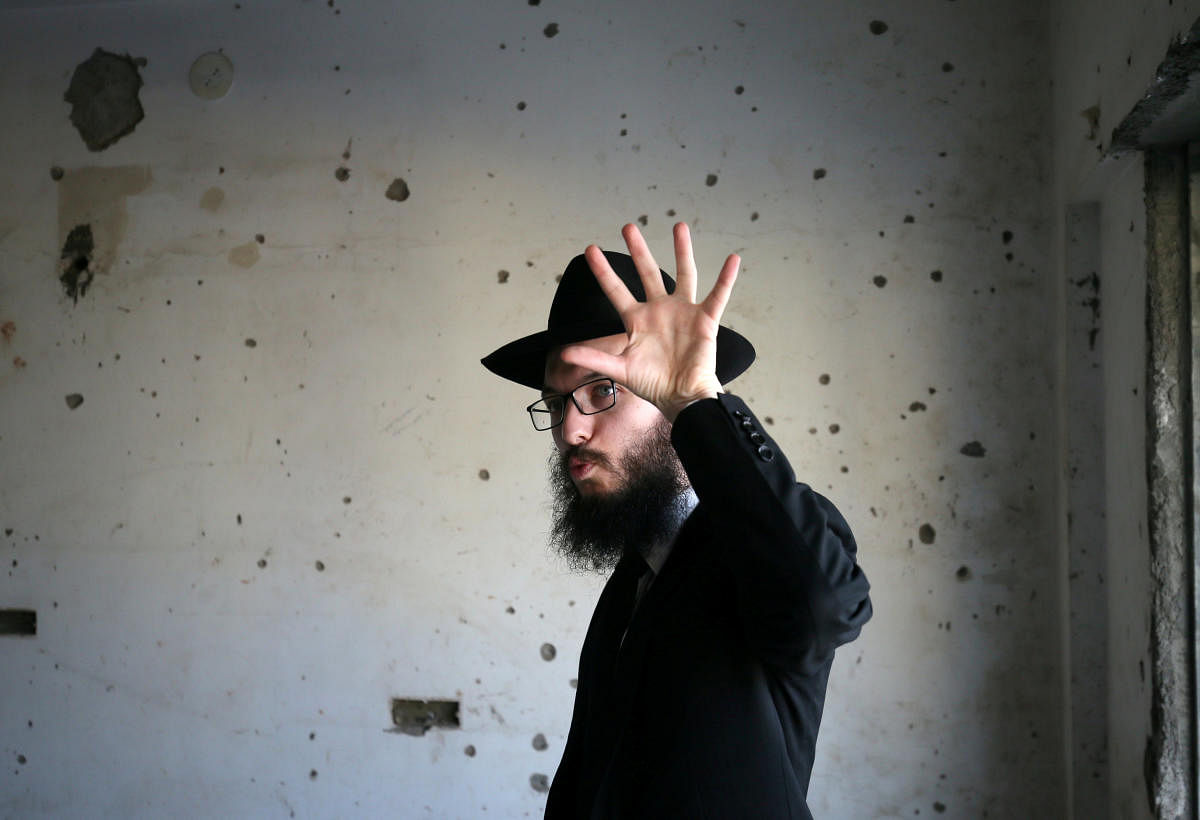 Rabbi Israel Kozlovsky gestures next to a wall riddled with bullet holes after the renaming of Nariman House as Nariman Light House, which was one of the targets of the November 26, 2008 attacks, in Mumbai, India, November 25, 2018. (REUTERS)