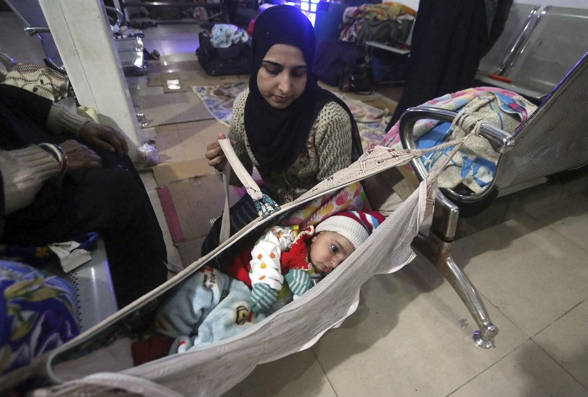 A stranded Indian passenger takes care of her child at Lahore railway station while waiting for the resumption of train to travel to India, in Lahore, Pakistan, Sunday, March 3, 2019. A Pakistani Cabinet minister says a key train service between Pakistan