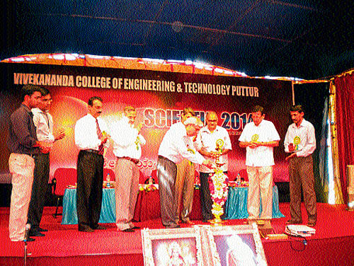 ISRO Advisor and NRSC (Hyderabad) former Director Dr V Jayaraman lights a lamp to inaugurate 'Scientia -2014' in the premises of Vivekananda College in Puttur on Tuesday.  DH Photo