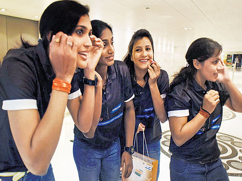 Indian women's kabaddi players Mamata Poojary, Tejaswini Bai, Sumitra Sharma and Anita Mavi apply make-up ahead of the felicitation function organised by Samsung on Monday. PTI