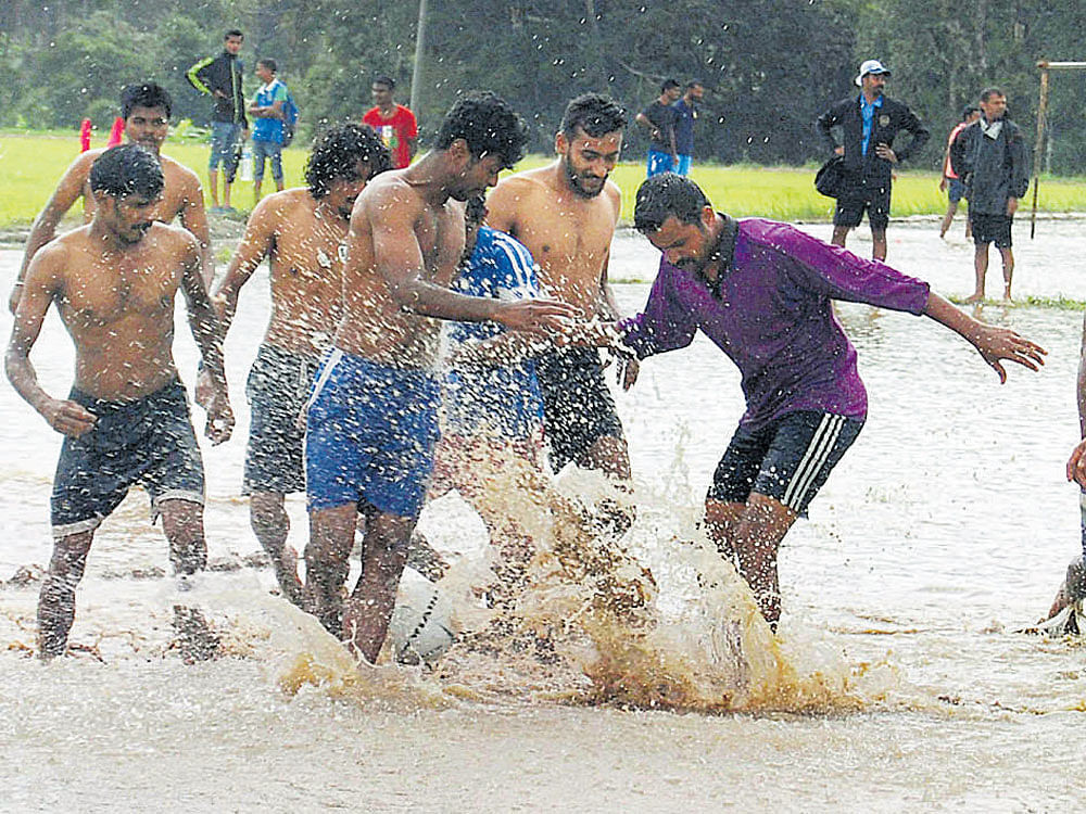 Youths take part in a marshy field football competition. DH photo