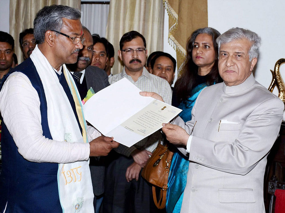 BJP legislature party leader Trivendra Singh Rawat meeting Uttarakhand Governor KK Paul to stake claim for forming the government in the State, in Dehradun on Friday. PTI Photo