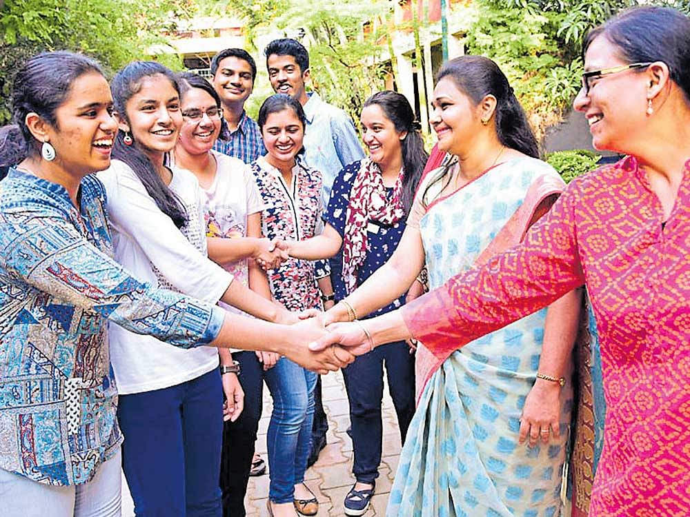Kensri School and College principal Renu (second from right) and other staffers greet meritorious students on the school premises at Kempapura. DH photo