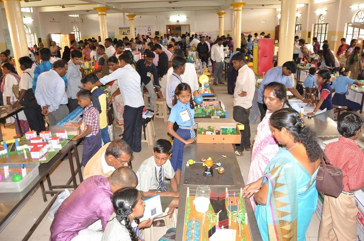 Students exhibit Science models during the district-level science expo in Mandya on Monday. (Right) Student Ajay Kumar explains about saving water, during the expo.