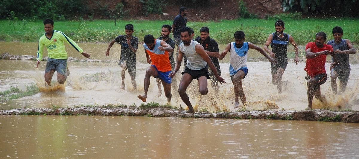 Youth take part in a marshy field race in Madikeri. DH PHOTO