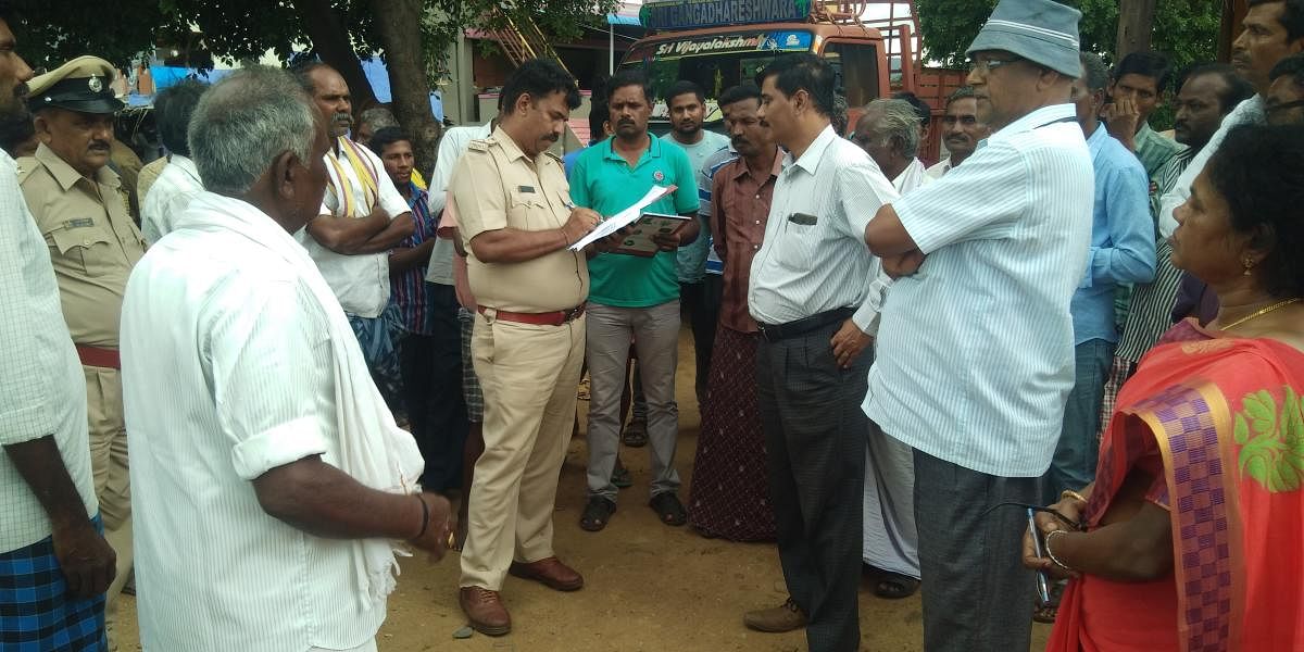 Officials of the Social Welfare department and police personnel collect details on untouchability practises in Hoogyam village, Hanur taluk on Tuesday.