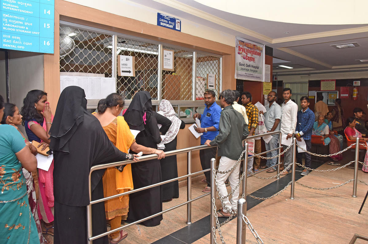 Patients wait in queue at a government hospital. The state government is now trying to attract specialists into government hospitals by fixing the incentives for procedures performed in a government hospital. (DH File Photo)