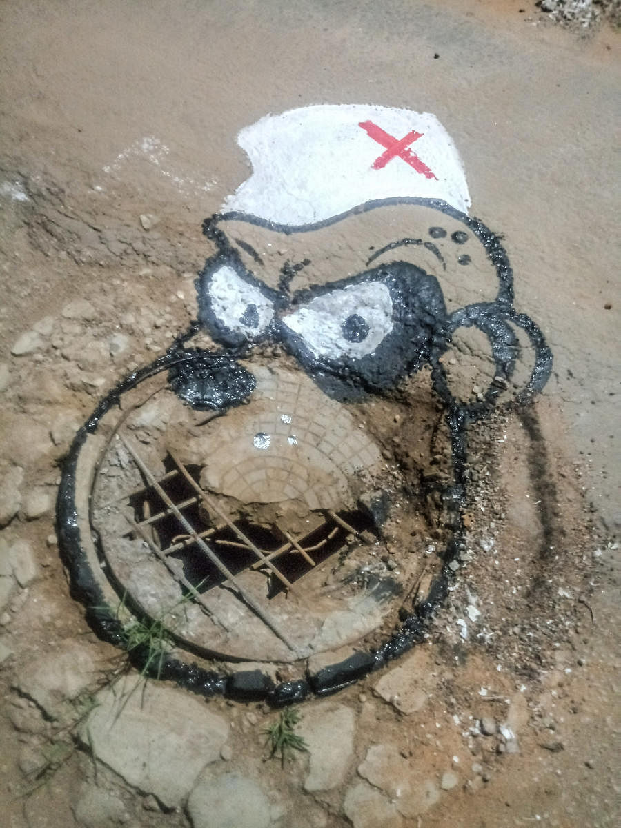 Artist Badal Nanjundaswamy's art work on pothole, at Saraswathipuram Swimming Pool Road in Mysuru in 2017. DH/PV PHOTOS