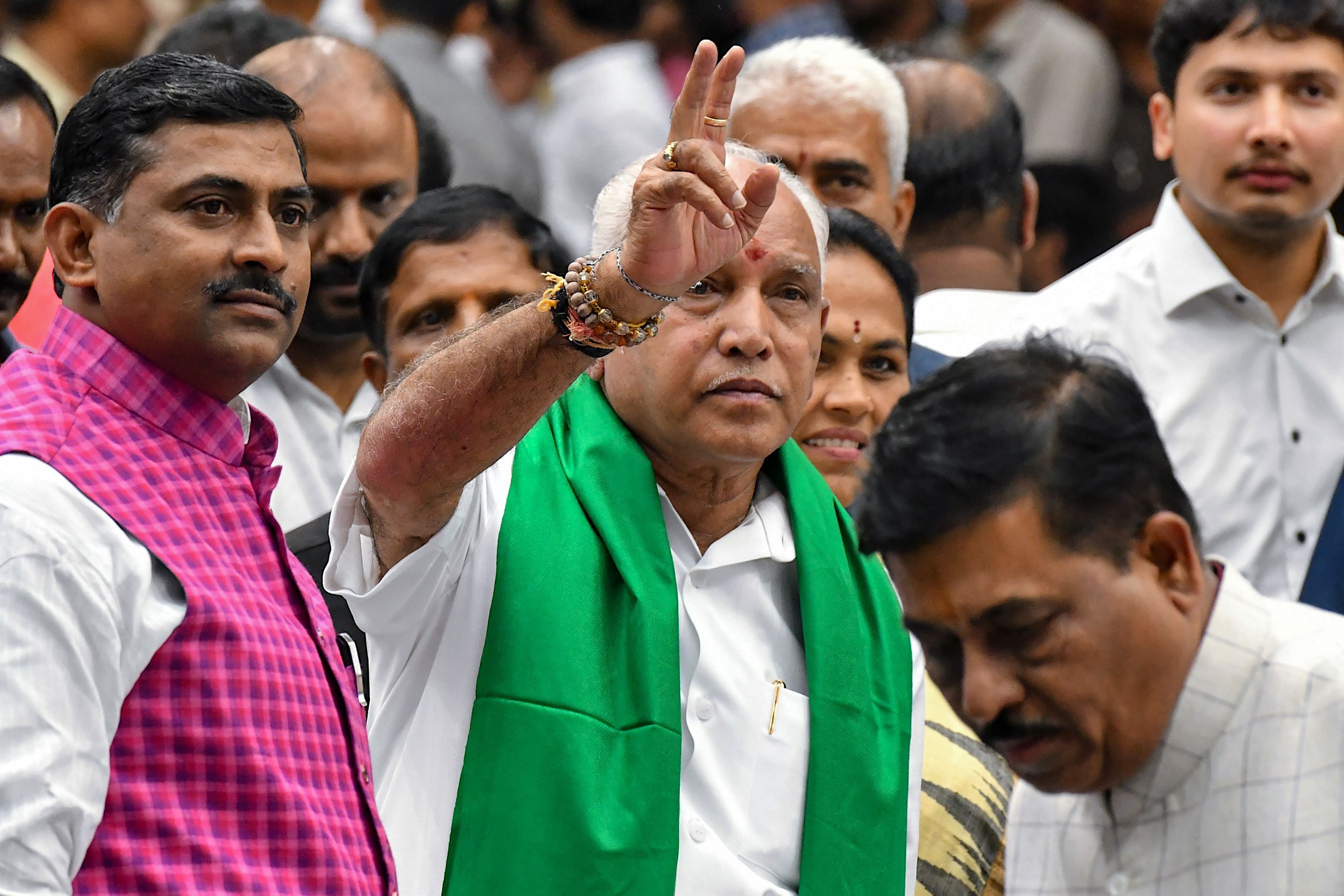 Senior leader of Bharatiya Janata Party (BJP), B.S. Yediyurappa (C), flashes the victory sign to his supporters and party workers prior to his swearing for the fourth time as the Karnataka Chief Minister. (AFP Photo)