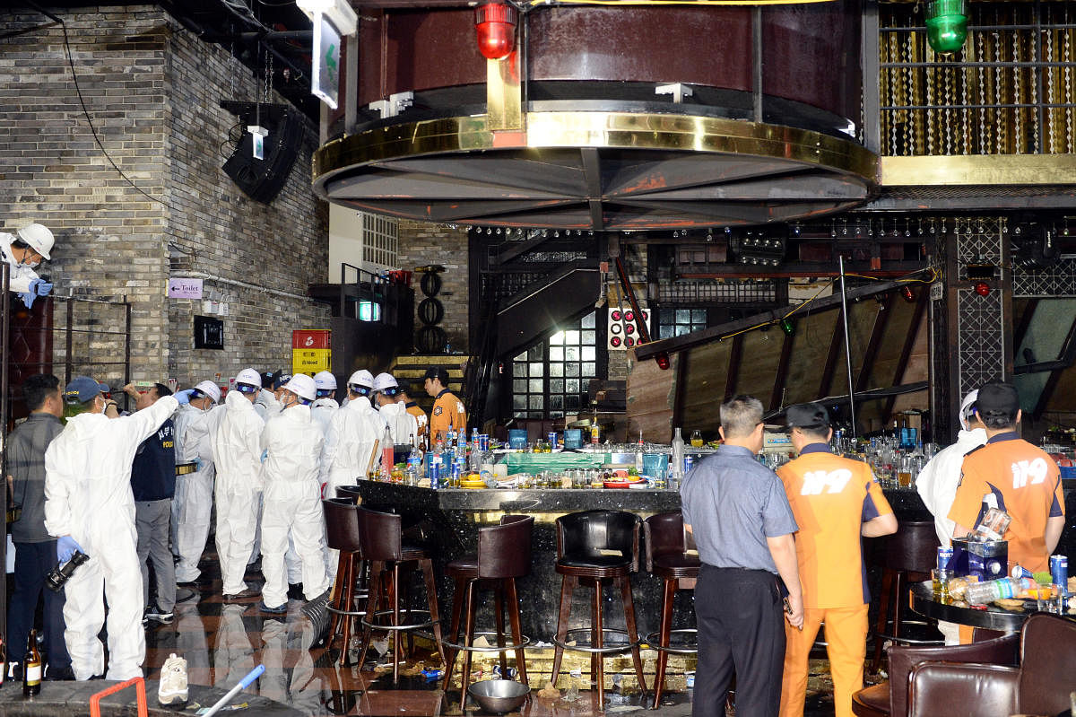 South Korean firefighters and officials examine the collapsed structure of a nightclub where several athletes competing at the World Aquatics Championships were dancing, in Gwangju (Reuters)
