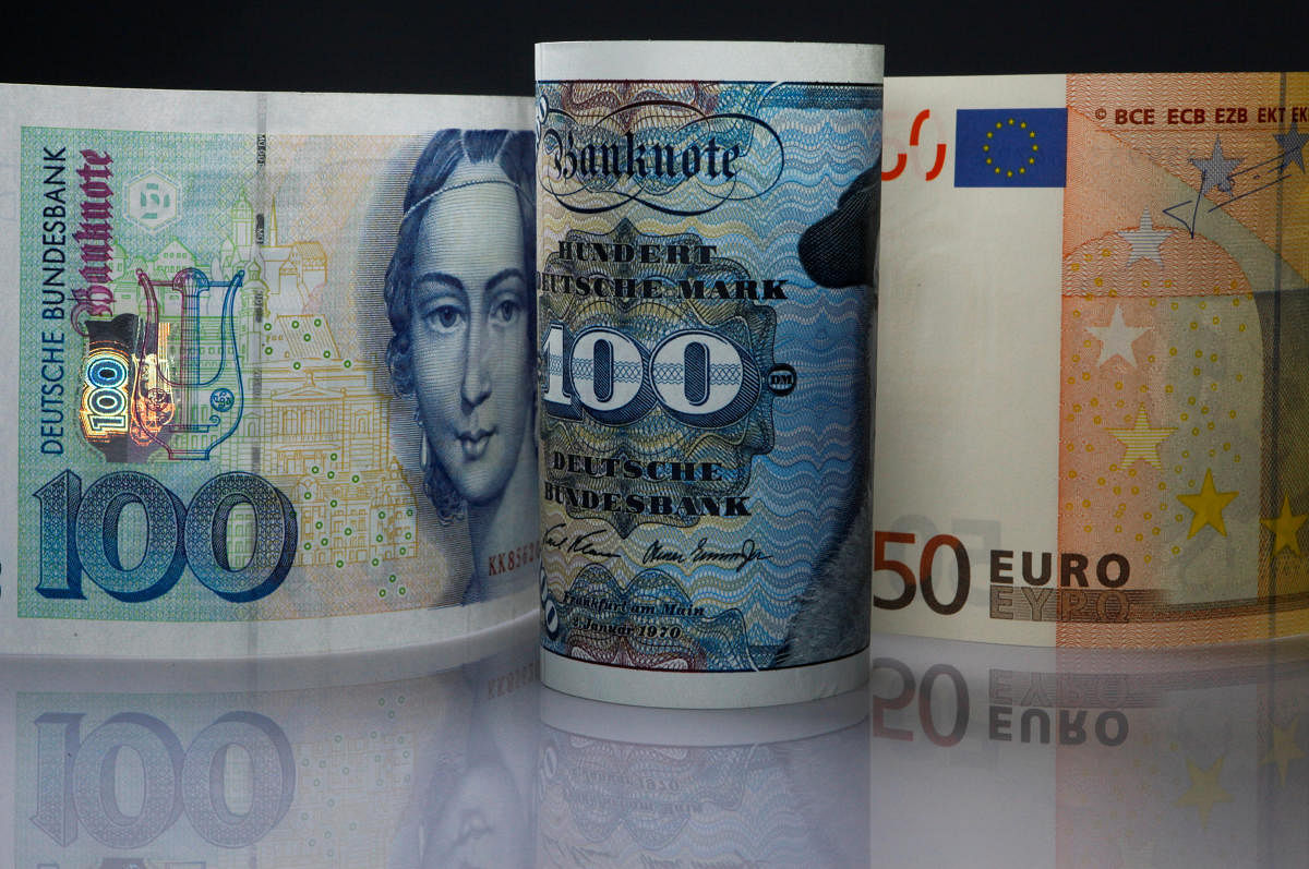 FILE PHOTO: One hundred Mark notes and fifty Euros note are seen in this photo illustration taken in Berlin on December 30, 2011. REUTERS/Pawel Kopczynski/File Photo