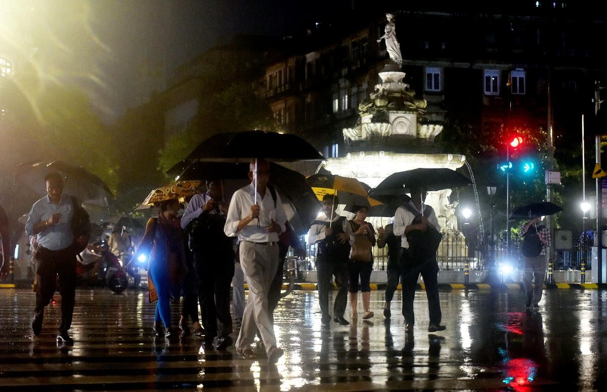 Mumbai: A pedestrians takes cover under an umbrella during heavy monsoon rain in Mumbai, Friday, July 26, 2019. (PTI Photo/Mitesh Bhuvad)(PTI7_26_2019_000263B)