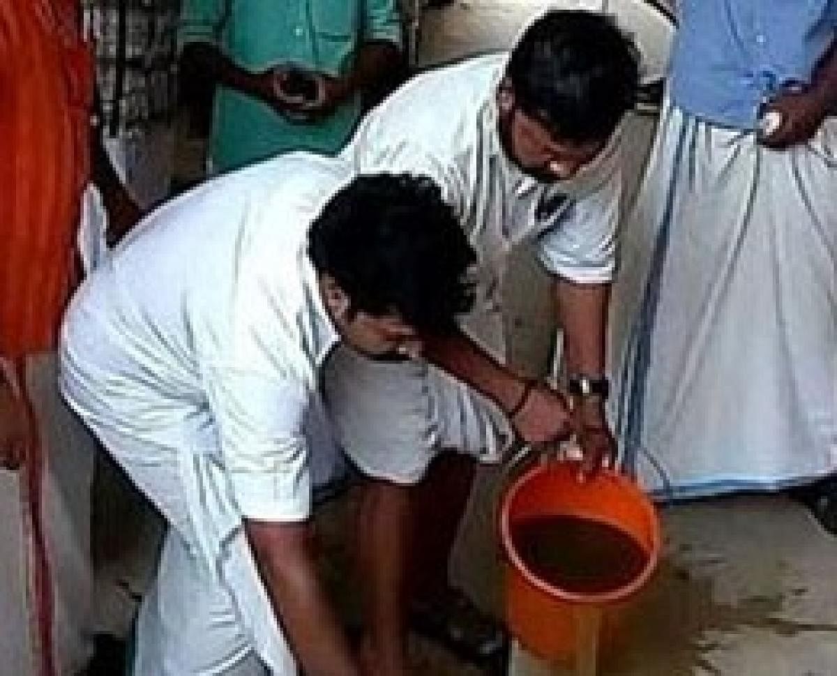A symbolic purification gesture carried out by a section of Youth Congress workers in Kerala. (DH Photo)