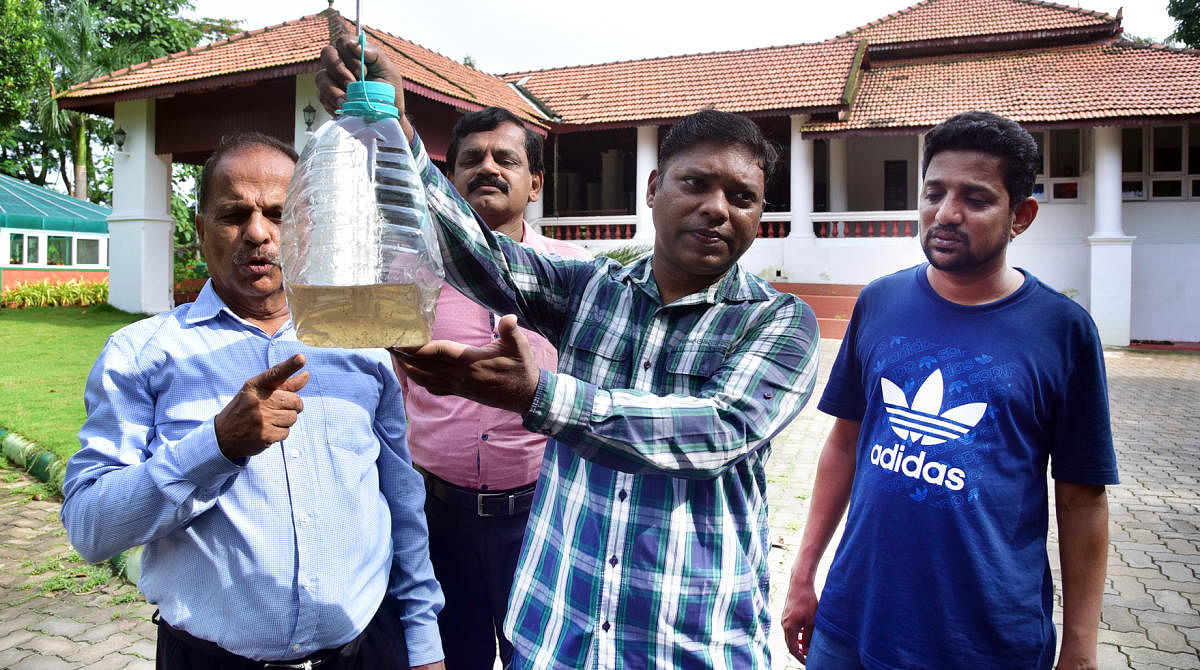 Deputy Commissioner S Sasikanth Senthil shows larvae found on the premises of DC's bungalow during Dengue Drive Day campaign held at Balmatta in the city on Sunday. Activist Suresh Shetty, District Health Officer Dr Ramakrishna and District Information an