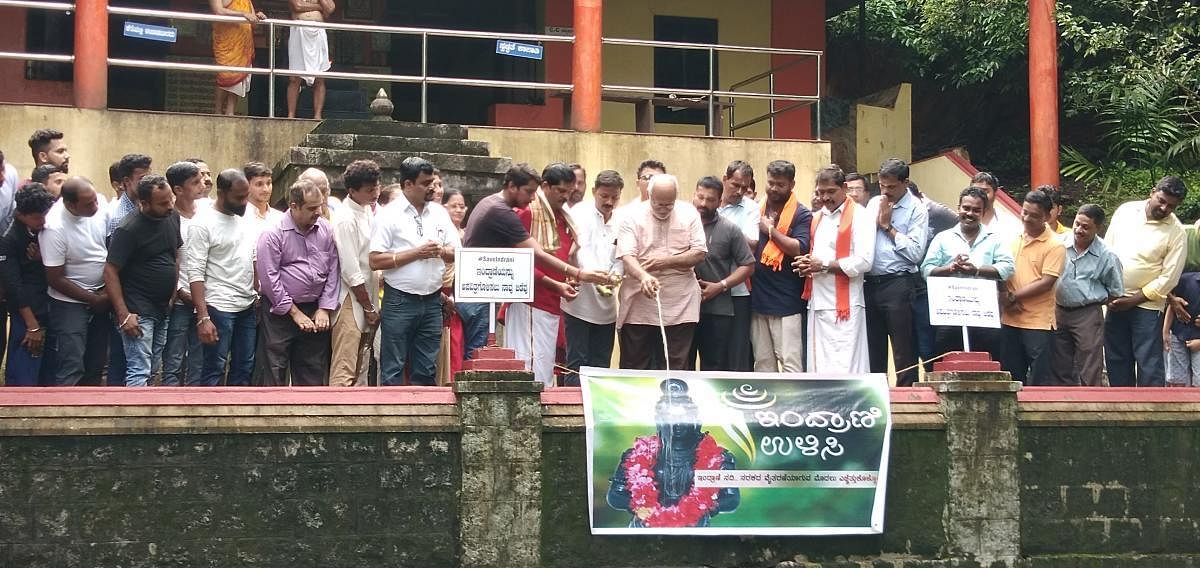 Udupi-based Human Rights Protection Foundation President Dr Ravindranath Shanbhag launches the motorbike rally by pouring milk into the Indrani river at Mukhyaprana Temple in Udupi on Sunday.