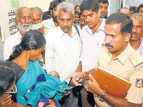 Devaraja police Inspector Kantharaj is seen enquiring Medical Superintendent of Cheluvamba Children's Hospital&#8200;Dr&#8200;Radhamani, after handing over the baby to Sharadamma's relative, in Mysore on Tuesday. DH Photo
