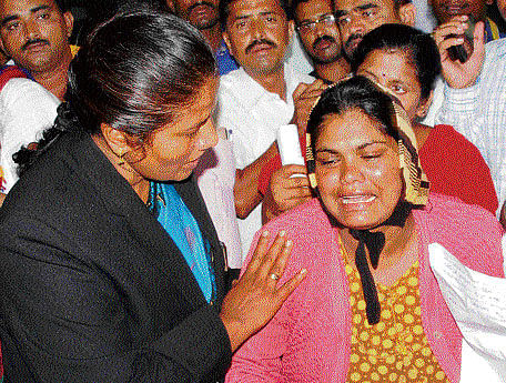 State Women's Commission chairperson Manjula Manasa consoles the baby's mother in Hassan on Wednesday. DH PHOTO