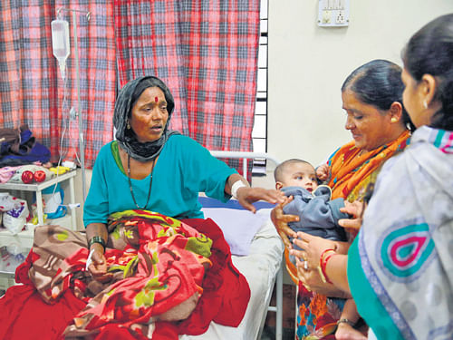 close call: Survivor Tanubai Lende touches her grandson Rudra, who was also injured in the landslide, at a hospital in  Manchar, Maharashtra, on Thursday. AP