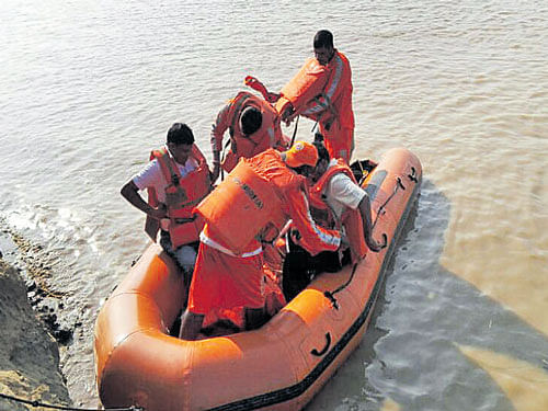 Rescue personnel take care of Roshni Kumari and baby  Krishna onboard the NDRF boat in Vaishali. DH Photo