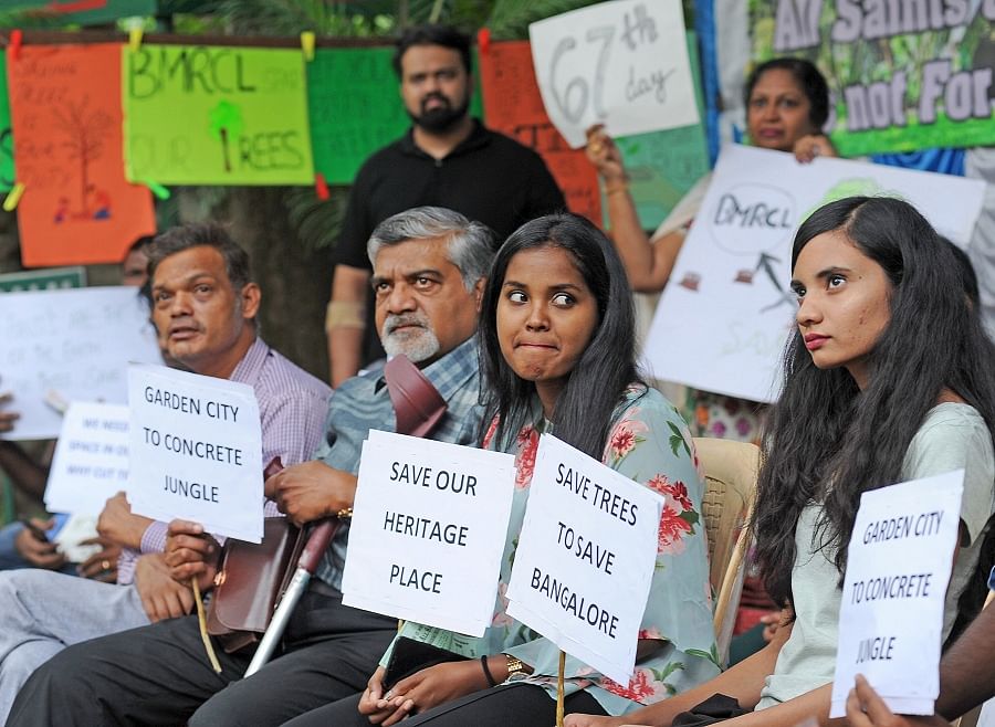 People staging a protest marking 67 days against BMRCL set to cut trees on the All Saints Church campus in Bengaluru. (DH Photo)