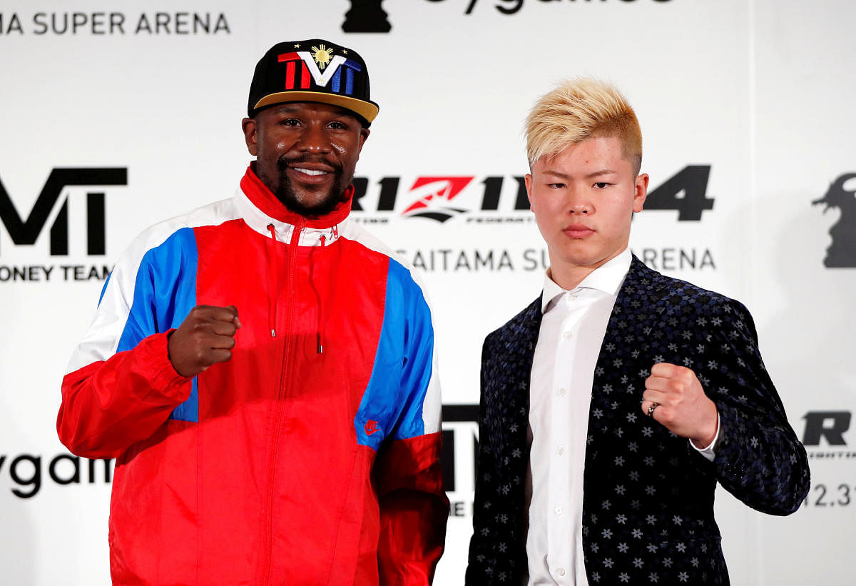 Undefeated boxer Floyd Mayweather Jr. of the U.S. poses for a photograph with his opponent Tenshin Nasukawa during a news conference to announce he is joining Japanese Mixed Martial Arts promotional company Rizin Fighting Federation, in Tokyo, Japan Novem