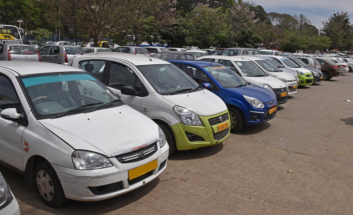 Ola and Uber cabs are parked at Freedom Park in Bengaluru. DH Photo/S K Dinesh