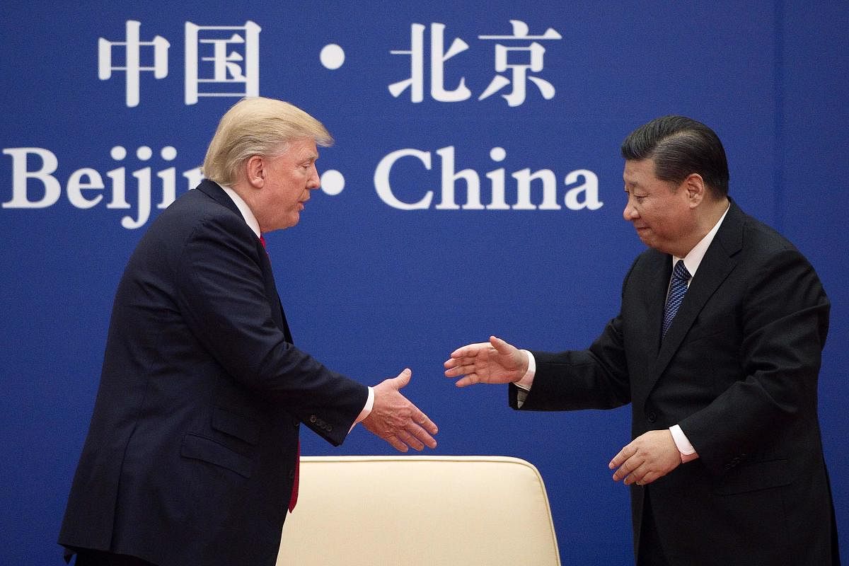 China's President Xi Jinping shakes hands with US President Donald Trump (L) during a business leaders event at the Great Hall of the People in Beijing in 2017 (AFP File Photo)