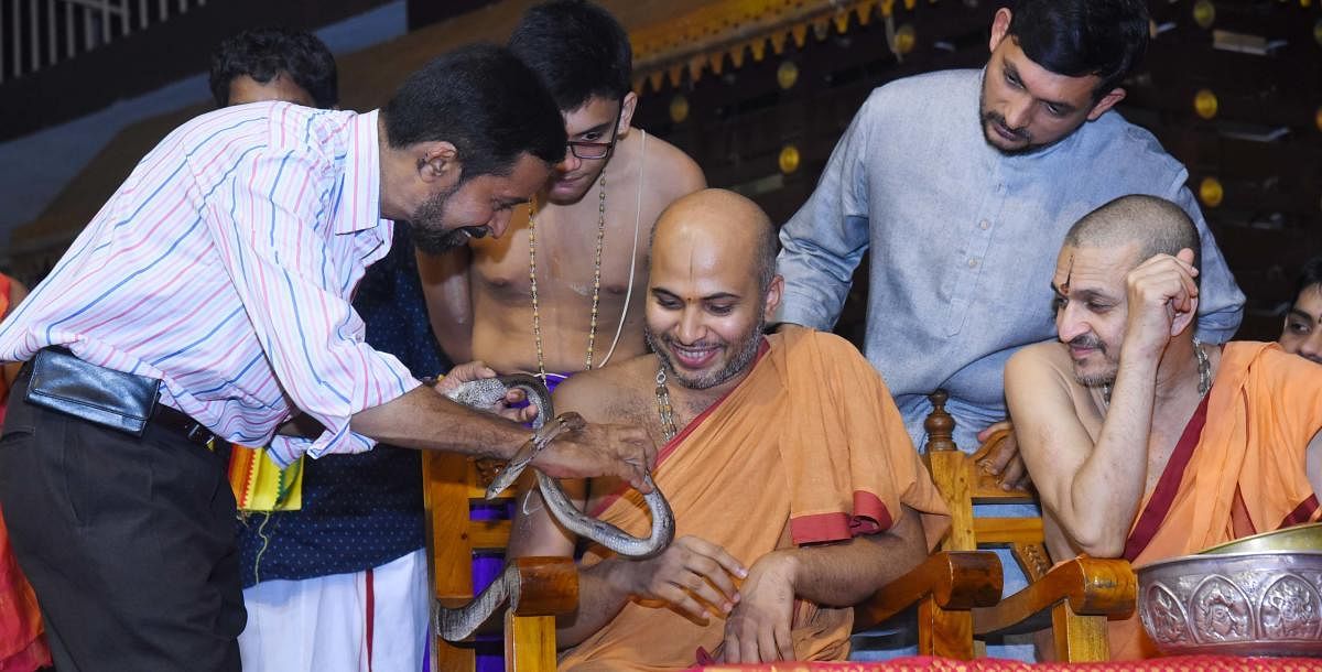 Well-known herpetologist Dr Ravindranath Aithal highlights special features of snakes to Eshapriya Swami of Admar Mutt and Vidyadeesha swamiji of Palimar Mutt at a programme organised in Rajanagan in Udupi.