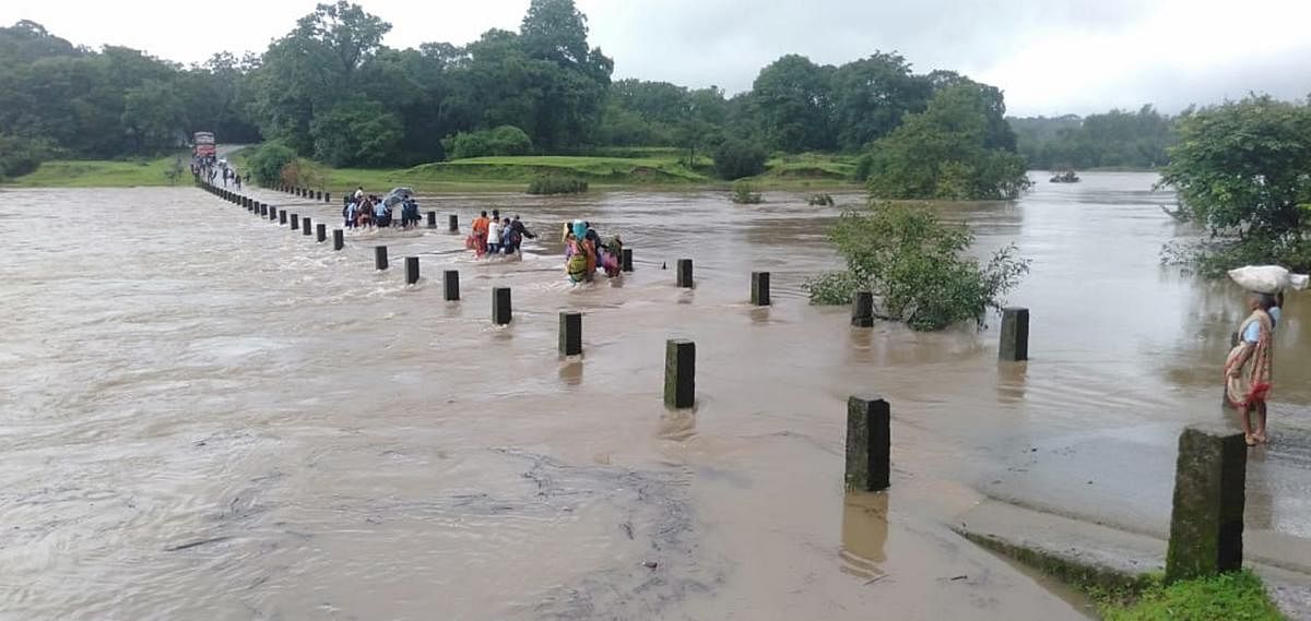 People walk across a submerged bridge across River Pandri in Joida taluk of Uttara Kannada district on Tuesday. (Right) Mallalli falls in Somwarpet taluk of Kodagu district is in full glory following heavy rains. River Kumaradhara cascades down the rocks