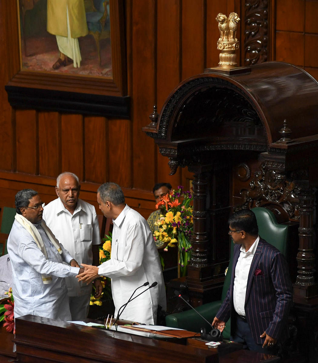Newly elected speaker of Karnataka Legislative Assembly, Vishweshwar Hegde Kageri being greeted by CM BS Yediyurappa and Former CM Siddaramaiah during the Assembly Session at Vidhan Soudha, in Bengaluru on Wednesday. B H Shivakumar