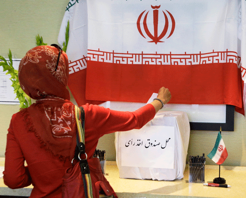 A woman places her ballot in a box as Iranians outside their country of origin cast ballots in Iran's presidential election, in a hotel meeting room in Los Angeles Friday, June 14, 2013. Iranian-Americans and expatriates cast ballots Friday in polling places across the United States, joining their countrymen half a world away in selecting the next Iranian president (AP Photo