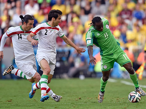 Nigeria's Victor Moses, right, is chased by Iran's Andranik Teymourian, left, and Khosro Heydari during the group F World Cup soccer match between Iran and Nigeria at the Arena da Baixada in Curitiba, Brazil, Monday, June 16, 2014. AP