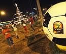 Residents gather next to a giant ball advertising the African Cup of Nations, in Luanda, Angola on Friday. AP