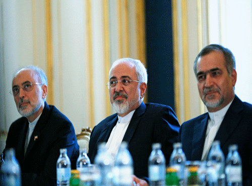 Iranian Foreign Minister Mohammad Javad Zarif and the Head of the Iranian Atomic Energy Organization Ali Akbar Salehi (L) meet with U.S. Secretary of State John Kerry (not pictured) at a hotel in Vienna, Austria. AP photo