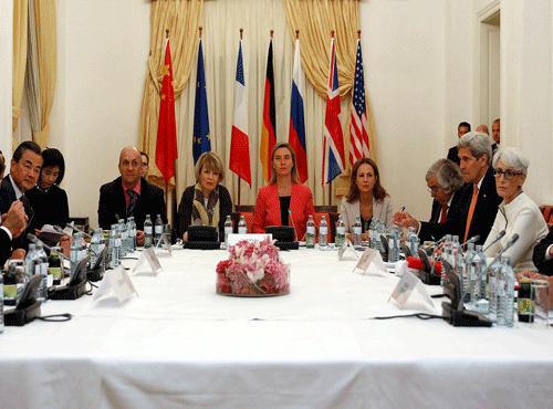 German Foreign Minister Frank-Walter Steinmeier, left, French Foreign Minister Laurent Fabius, 2nd left, Chinese Foreign Minister Wang Yi, 3rd left, European Union foreign policy chief Federica Mogherini, centre in red, U.S. Secretary of State John Kerry, 4th right, and Russian Foreign Minister Sergei Lavrov, right, meet at a hotel in Vienna Monday. AP photo