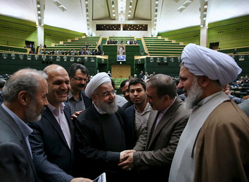 Iranian President Hassan Rouhani is greeted during a session at the Iranian parliament to present the draft budget for the next Iranian fiscal year in Tehran. Reuters