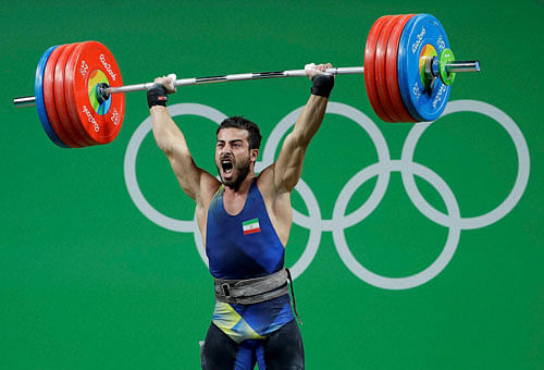 Kianoush Rostami, of Iran, yells during his final lift in the clean and jerk portion of the men's 85kg weightlifting competition to win the gold medal at the 2016 Summer Olympics in Rio de Janeiro, Brazil, Friday, Aug. 12, 2016. AP/PTI