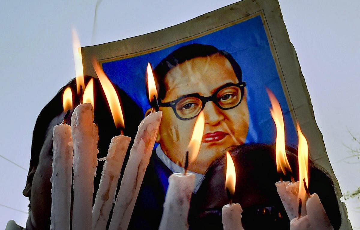 A poster of Dr B R Ambedkar is seen as Dalit activists participate in a candlelight vigil to protest against Supreme Court's ruling on SC/ST Act, in Kolkata. PTI FILE PHOTO