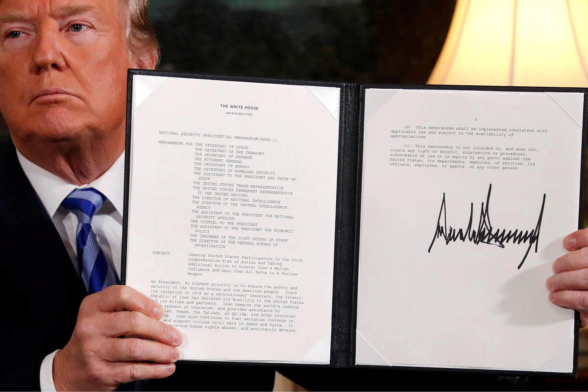 U.S. President Donald Trump holds up a proclamation declaring his intention to withdraw from the JCPOA Iran nuclear agreement after signing it in the Diplomatic Room at the White House in Washington. (REUTERS File Photo)