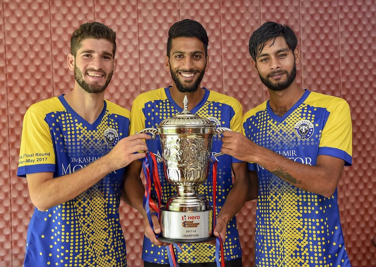 Real Kashmir FC players pose with the second division league trophy in New Delhi. PTI Photo