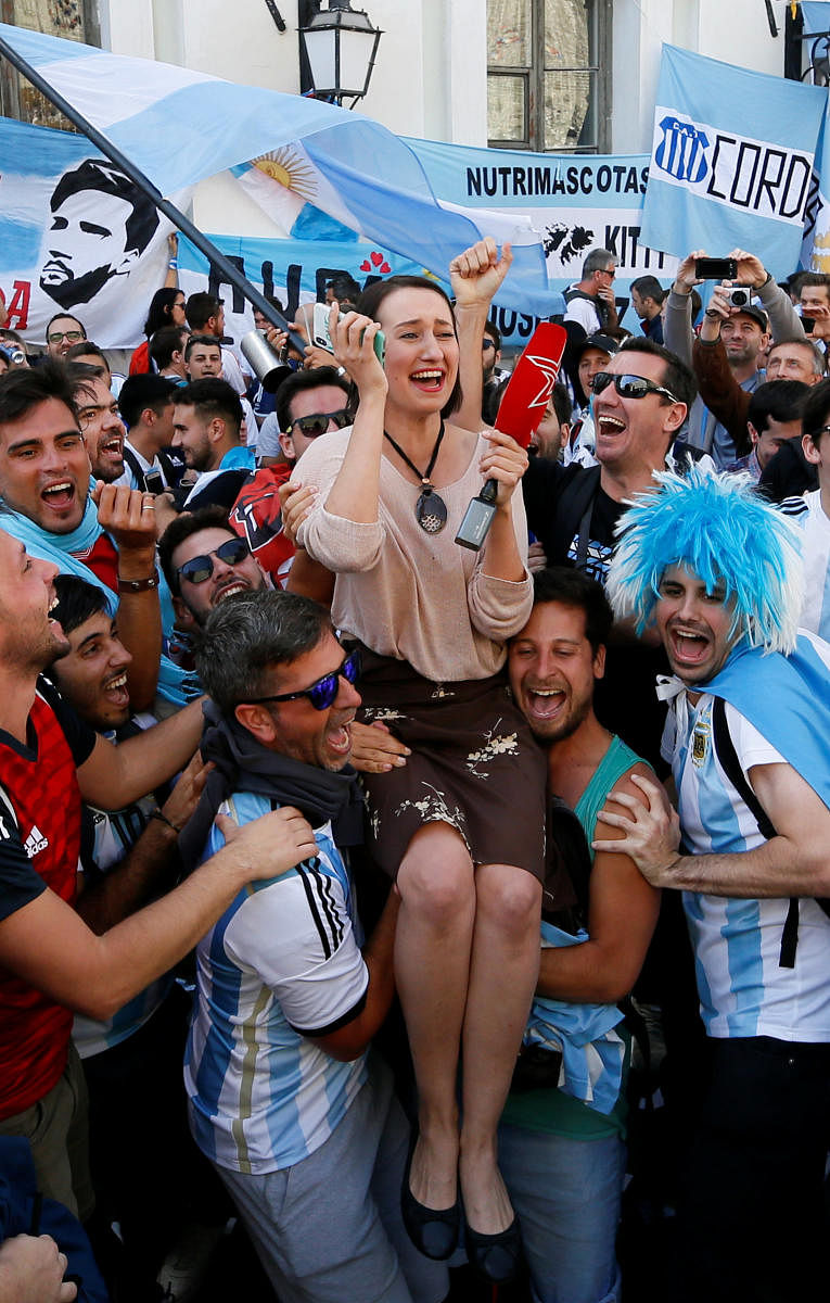 Supporters of the Argentine national soccer team lift a journalist during a gathering in central Moscow. Reuters