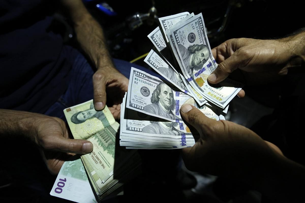 A man exchanges Iranian Rials against US Dollars at an exchange shop in the Iranian capital Tehran on August 8, 2018. AFP